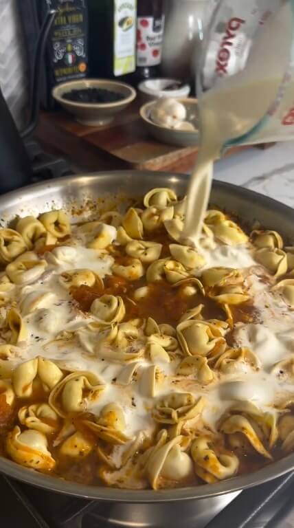 Adding tortellini pasta and heavy cream